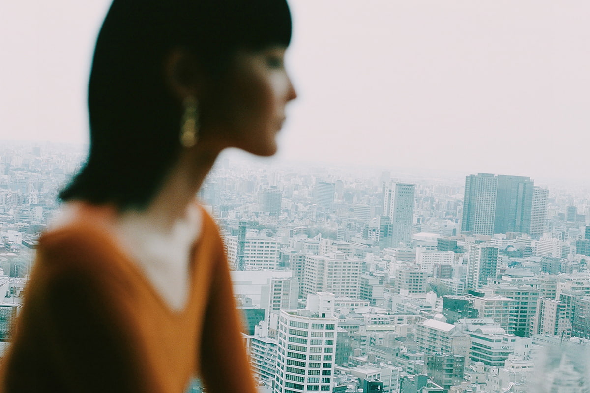 Femme à la fenêtre avec une vue sur Tokyo