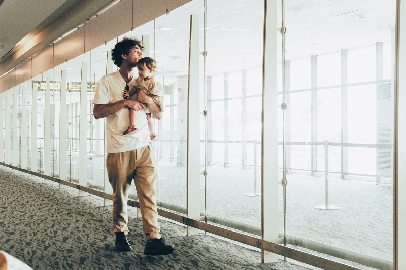 Bébé porté par son père à l'aéroport