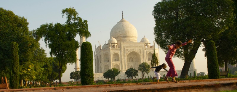 des enfants dansent devant un monument en Inde