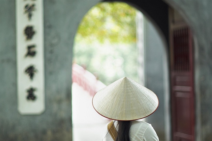 Femme avec un chapeau traditionnel au Vietnam