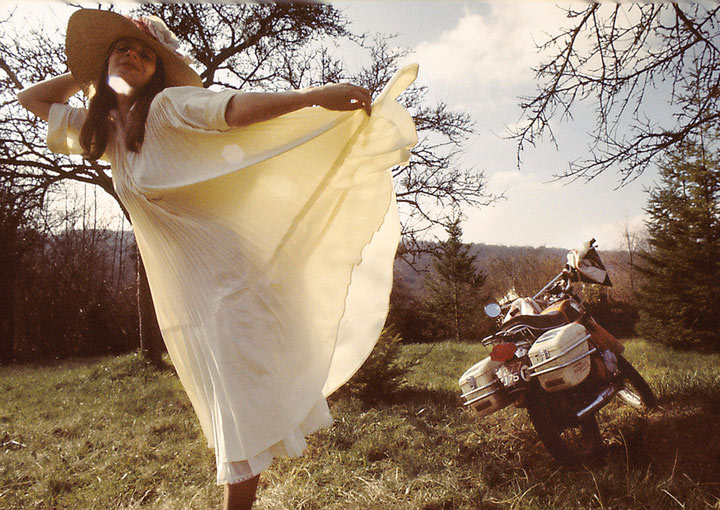 Femme avec une jolie robe blanche et sa moto