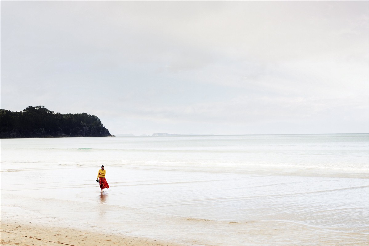 femme sur une plage de nouvelle zélande