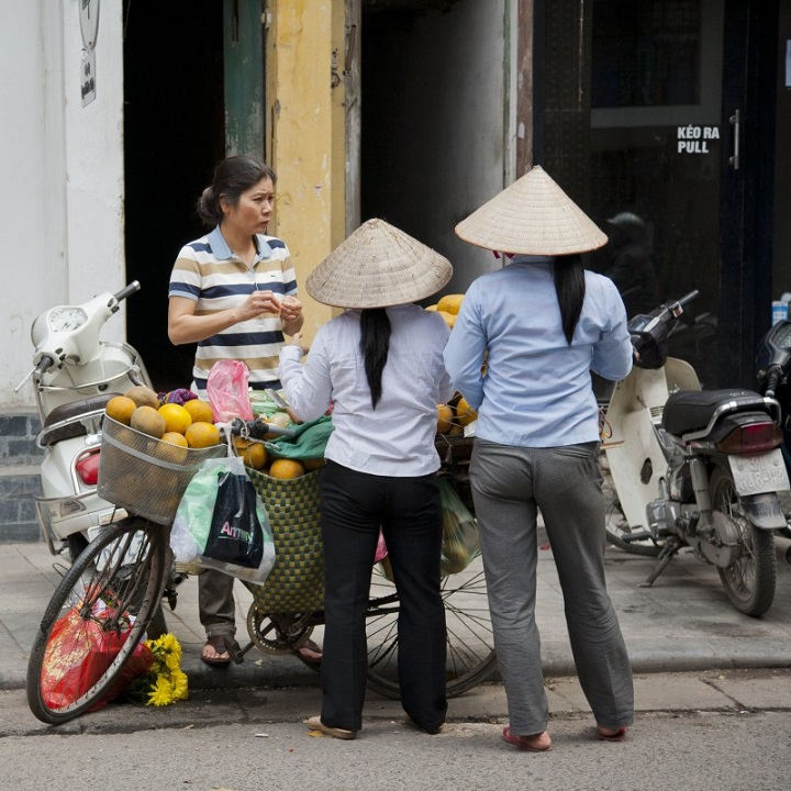 Femmes qui poussent des vélos chargés de marchandises
