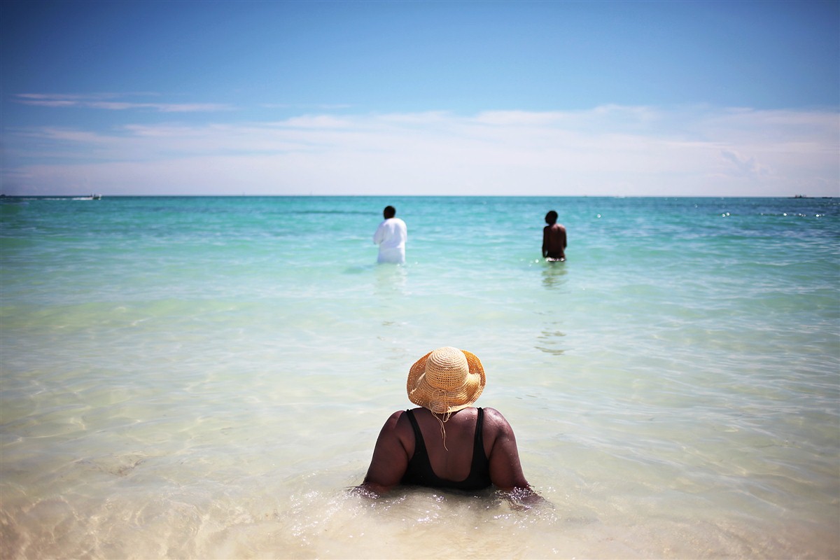 personnes les pieds dans l'eau aux Bahamas