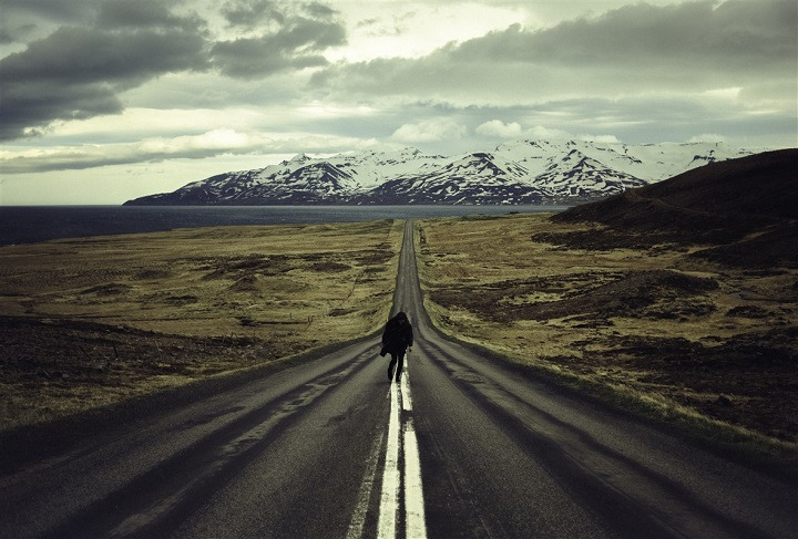 Homme qui marche sur une route d'Islande