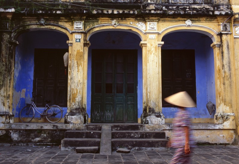 une femme marche dans les rues de Hoi An